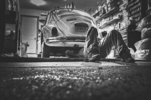 Uk Jobs With Visa Sponsorship​: Automotive technician performing MOT inspection in a UK garage.
